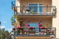 An apartment with multiple balconies. The image shows a corner of an apartment with two balconies looked up from the front on one edge and three more on the other side.