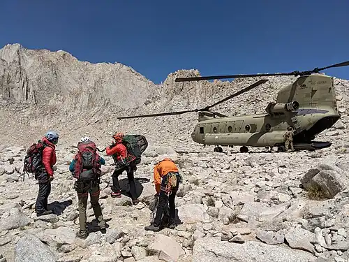 National Guard helicopter delivers a SAR crew to rescue an injured climber on Mount Whitney