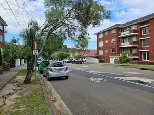 Street with a bicycle pictogram painted on the road and a traffic sign with bicycle icon and arrow.
