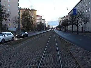 Straßenbahn mit besonderen Bahnkörper. Das Bahngelände der Straßenbahn ist durch Bordsteinen von der Straße getrennt.