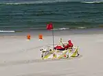 A lifeguard on duty at a beach natural=beach lifeguard=yes