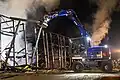 excavator teraing down burned building
