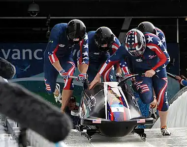 Závodník Steven Holcomb, vpravo vpředu, vede USA-1, tzv. "The Night Train", tým složený z Justina Olsena, Steva Meslera a Curtise Tomasevicze při startovním čase 4,77 vteřin ve třetím kole olympijského závodu čtyřbobů ve Whistleru, Britské Kolmbii na zimní olympiádě 2010. Čtveřice vyhrála první medaili pro USA v tomto sportu po 62 letech.