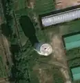 1/2 Water tower in Pyongyang, with its round, vertical structure, and its cast shadow clearly visible on the ground (Esri satellite imagery).