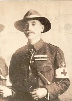 Black and white photograph of Markos Mindler at age 56, in the photo, he is wearing a greek scout suit and hat as well as a red cross paramedic armband.