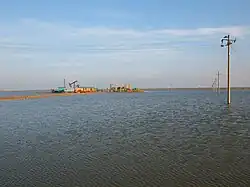 Oil wells on some raised land in the middle of a body of water