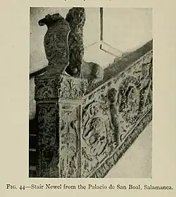 A black and white photograph of the side of a stair in stone withe very ornate foliage and putti. A standing lion holds a scroll. It is labeled as "FIG. 44".