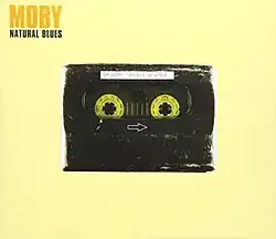 Album cover showing Moby's "Natural Blues" single with a cassette tape on a yellow background