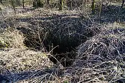 The former open pit (E).