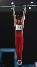 The gymnast has reached the hanging position and is ready to start the exercise
