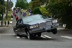 A 1994 Cadillac Fleetwood lowrider 3-wheeling during the Fiestas Patrias Parade, South Park, Seattle, Washington