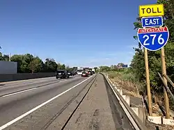 Another stretch of road with sign, photographed from the shoulder