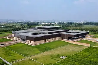 An overhead view of a large museum in a grassy environment
