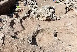 Part of the surface of one of the adjacent outdoors. The area has been punctuated by modern looters' pits.