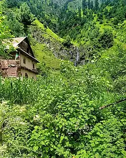 A traditional pastoral hut beside a natural spring, reflecting rural architecture