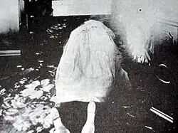 Woman lying on floor next to bed