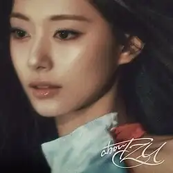 An image of Tzuyu wearing a cyan colored dress. The album title is displayed on the lower right side of the image.