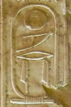 Inscription in raised hieroglyphs on a wall of light brown color