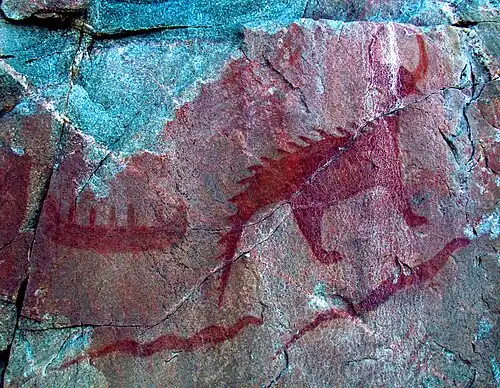 Ojibwa pictographs on cliff-face at Agawa Rock, Lake Superior Provincial Park of a boat and Mishipeshu, an animal with horns, painted with red ochre