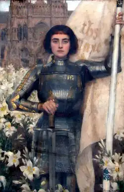 Joan of Arc depicted with short black hair in full body armor holding a flag and a sword; the breastplate reads "Jesus and Mary" in Latin