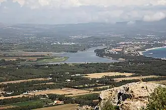 a body of water surrounded by greenery.