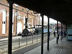 A view from the original 1830 platform of the Liverpool Road terminus, with the replica locomotive 'Planet' and carriages, and original 1830 warehouse behind, 2009