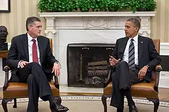 US Ambassador Rick Olson with President Barack Obama, in the Oval Office, with guttae on the Ionic fireplace.