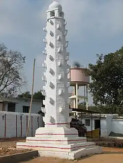 A white stambha standing tall at the temple
