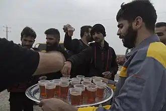 An Iranian volunteer distributing free drinks