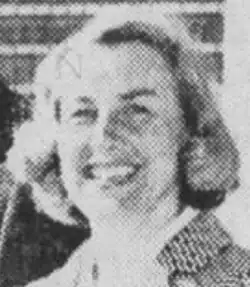 A smiling middle-aged white woman with blond hair, photographed outdoors