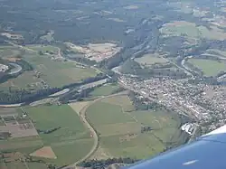 A small town surrounded by farmland and forestland, crisscrossed by rivers and roads.