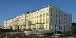 Block of white houses with a blue sky in the background