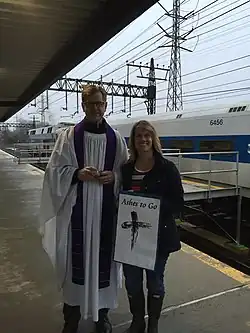 A priest has an "Ashes to Go" station for commuters at a train station.