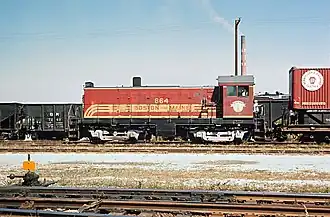 A red locomotive in a freight yard