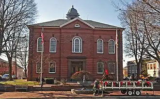 The façade of the Harford County courthouse, with a fountain and flags in front of it