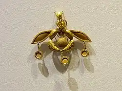 The Bee Pendant, an iconic Minoan jewel; 1700–1600 BC; gold; width: 4.6 centimetres (1.8&nbsp;in); from Chrysolakkos (gold pit) complex at Malia; Archaeological Museum of Heraklion (Heraklion, Greece)[40][41]