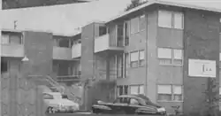 A black and white photo of a small apartment building