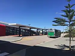 Bus at bus interchange with railway station in background