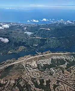 Aerial view directed west showing interchange with SR 92; Crystal Springs Reservoir runs north-south parallel to I-280 through the middle of the photograph