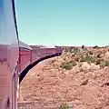 Flash floods regularly washed away bridges and track on the narrow-gauge railway. The Ghan is climbing out of the Finke River depression after track was laid on the river bed as a cheap solution.