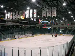 Photo of ice rink with team banners hanging from the ceiling