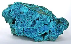 Powder-blue chrysocolla as stalactitic growths and as a thin carpet in vugs inside a boulder of nearly solid tyrolite, from the San Simon Mine, Iquique Province, Chile (size: 14.1&nbsp;cm ×&nbsp;8.0&nbsp;cm ×&nbsp;7.8&nbsp;cm (5.6&nbsp;in ×&nbsp;3.1&nbsp;in ×&nbsp;3.1&nbsp;in))