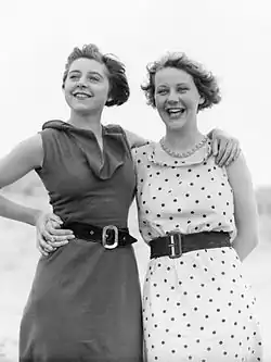 two young women in sleeveless dresses posing