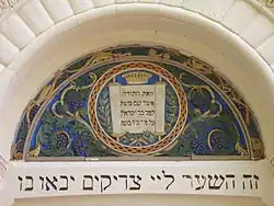 Tile art above center doorway (west side).