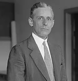Photograph of a man wearing a suit and tie