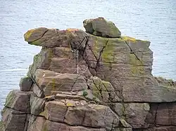 On a rocky outcrop, the top of the stack, is a tangle of ropes and carabiners.