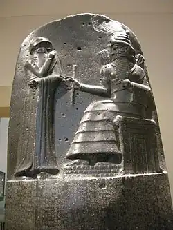 The only other surviving large image from the time: top part of the Code of Hammurabi, c.&nbsp;1760&nbsp;BCE. Hammurabi before the sun-god Shamash. Note the four-tiered, horned headdress, the rod-and-ring symbol and the mountain-range pattern beneath Shamash' feet. Black basalt. Louvre, Sb&nbsp;8.