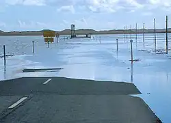Flooded road with white building