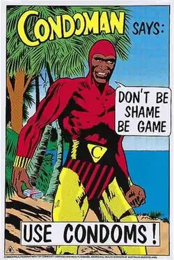 A comic-style poster depicting a dark-skinned male superhero in a red, yellow, and black costume holding a small box in one hand. The text on the poster reads: "Condoman says: Don't be shame, be game – use condoms!"
