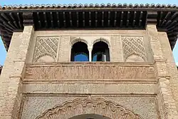 The decoration above the archway of the entrance, including the Kufic inscription
